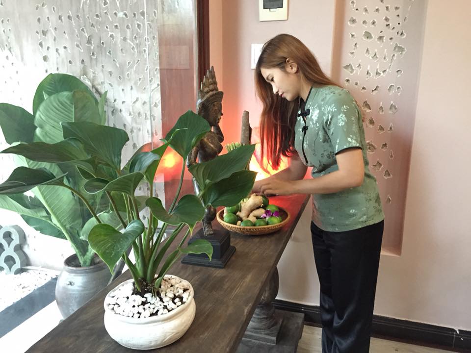 Vietnamese masseur arranges the herbal decor at one of Hoi An's spas
