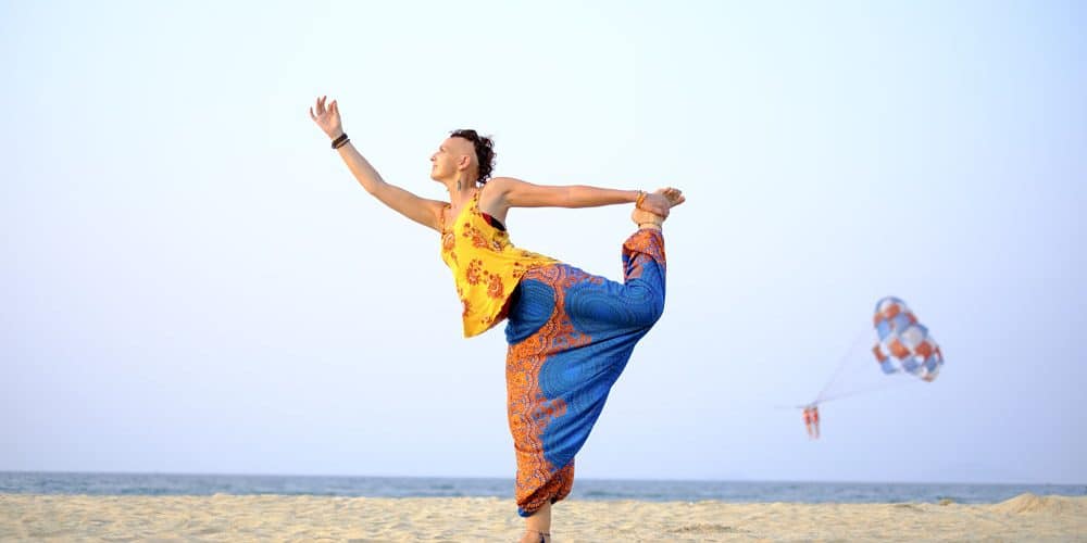 Image of a lady doing yoga on the beach