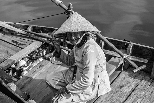 A lady wearing a traditional Vietnamese hat to fish