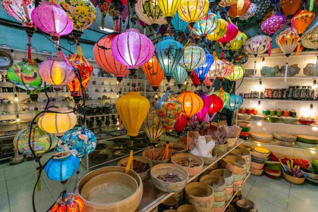 Colorful lanterns hanging from the ceiling illuminate craft baskets, ceramic plates, bamboo bowls and hoards of other souvenirs for sale at Viet A souvenir shop, Hoi An, Vietnam