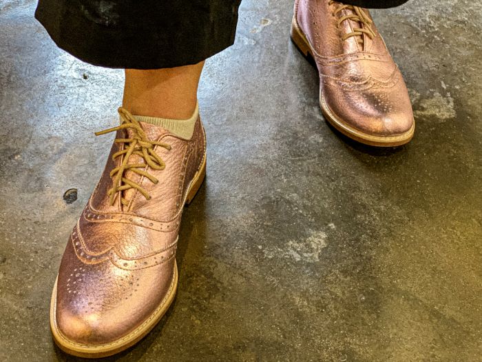 Close up of a woman wearing the oyster pink leather shoes she custom-designed in the Friendly Leather Shop, Hoi An