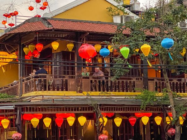 Colorful lanterns hanging over the balcony of a restaurant near Hoi An Night Market