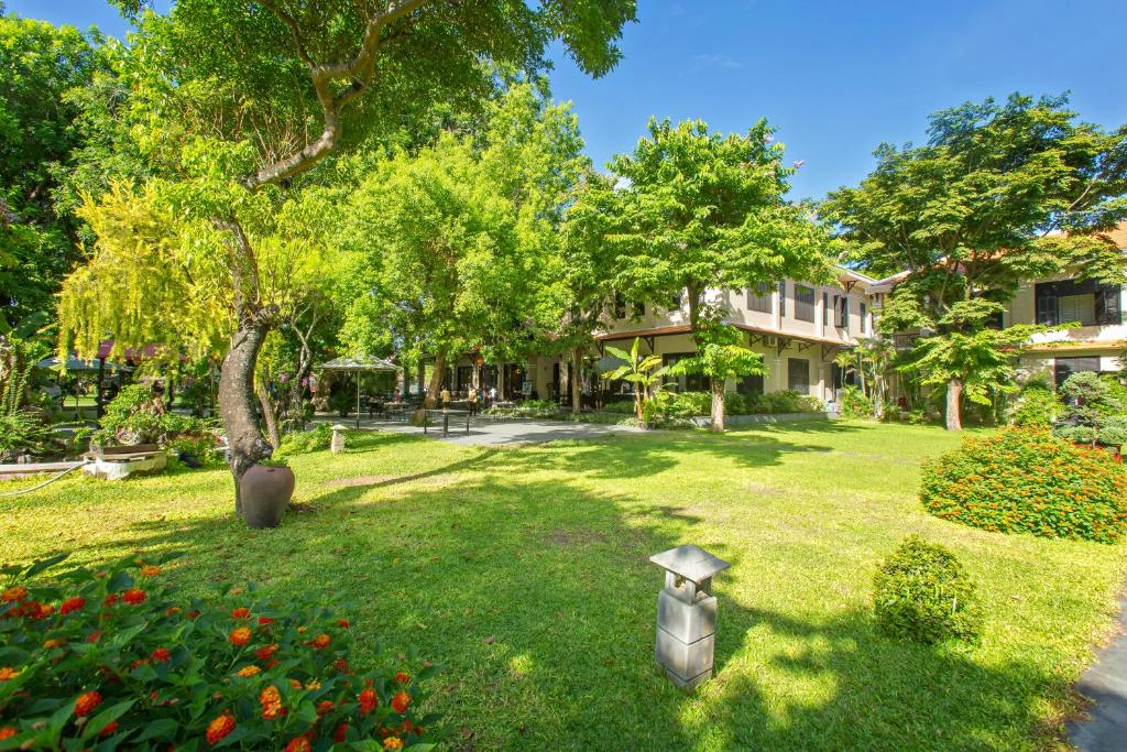 Garden courtyard at Hoi An Historic Hotel with lush greenery and colonial-style buildings in Hoi An Vietnam